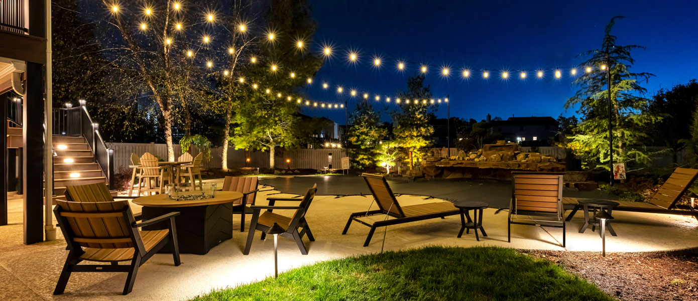 A patio with chairs and tables and lights